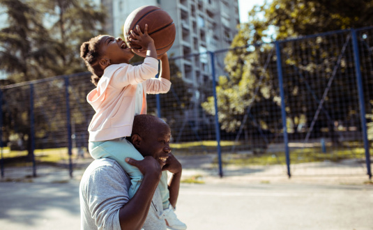 Man and daughter playing basketball