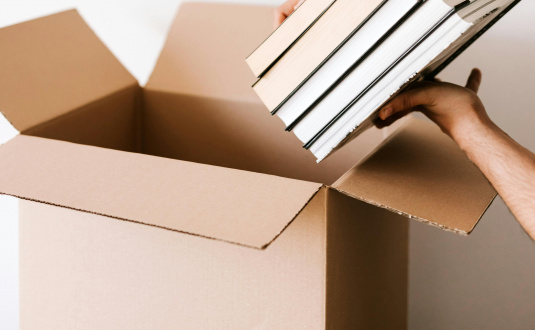 Person packing books into moving box